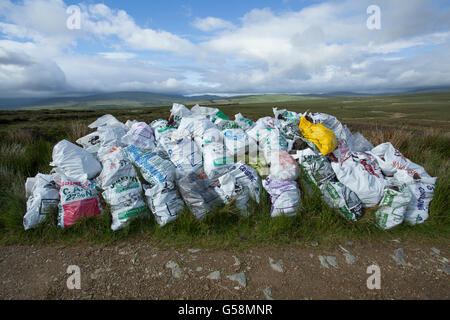Sacchi di torba turf impilati a lato della strada in Irlanda Foto Stock