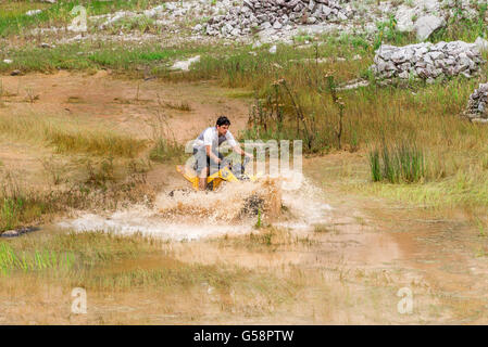 Minas Gerais, Brasile, Dec,27 - 2015: uomo nella natura andare fuori strada su 4x4 quad bike attraverso la pozza di fango in campagna. Foto Stock