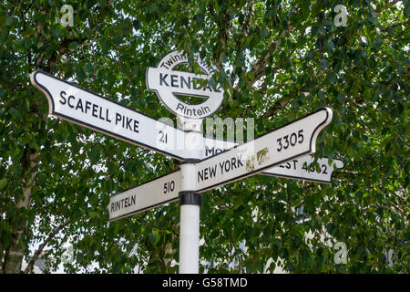 Segno posto nel centro della città di Kendal Cumbria gemellato con Rinteln distanze tedesco a Rinteln New York Everest Scafell Pike Foto Stock