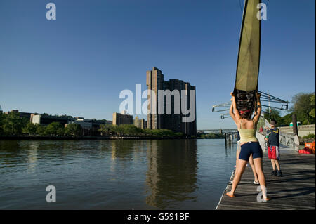 I rematori di preparare per mettere una barca in acqua da Peter Jay Sharp Boathouse sul fiume di Harlem in New York, USA, 5 giugno 2005. Foto Stock