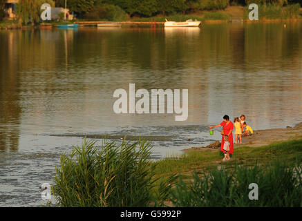 La gente del posto gode del tramonto sul lato del fiume a Donetsk, Ucraina. Foto Stock