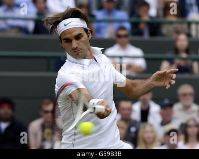 Roger Federer della Svizzera si scalda per la sua partita contro Albert Ramos della Spagna durante il giorno uno dei Campionati di Wimbledon 2012 presso l'All England Lawn Tennis Club di Wimbledon. Foto Stock