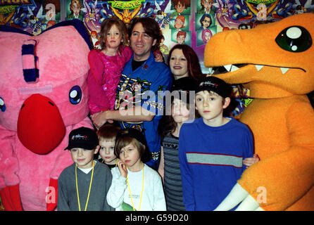 Il critico televisivo Jonathan Ross, sua moglie Jane Goldman e la loro figlia Betty Kitten (tra le braccia di Jonathan) e il figlio Harvey Kirby (terza a sinistra, in basso), in prima assoluta per il film per bambini Digimon: The Movie, al Planet Hollywood, nel West End di Londra. Foto Stock