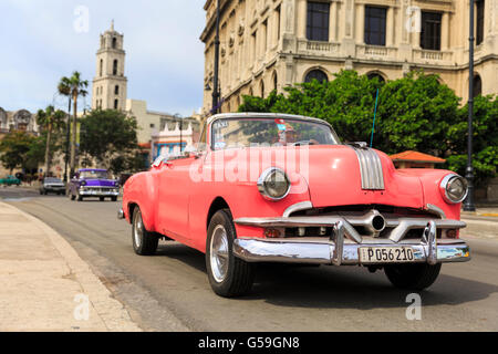 Rosa American degli anni cinquanta la Pontiac convertible classico auto taxi guida in Havana, Cuba Foto Stock