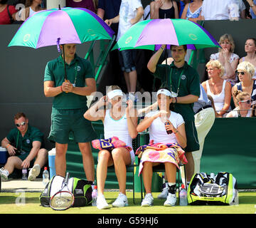 Naomi Broady della Gran Bretagna (a sinistra) e Johanna Konta in una pausa nella loro partita contro Kveta Peschke della Repubblica Ceca e Katarina Srebotnik della Slovenia durante il quarto giorno dei campionati di Wimbledon 2012 all'All England Lawn Tennis Club, Wimbledon. Foto Stock