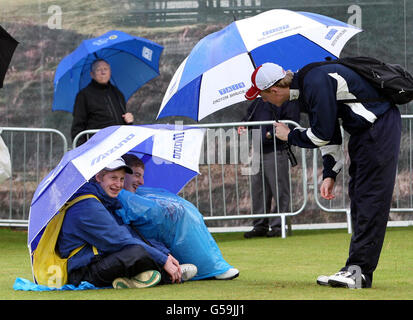 Golf - 2012 Irish Open - giorno uno - Royal Portrush Golf Club. La gente si ripara dalla pioggia poiché il gioco è sospeso a causa del maltempo durante il giorno uno degli Irish Open al Royal Portrush Golf Club, Portrush. Foto Stock