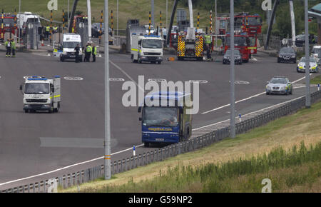 Un pulmino di deposito delle bombe passa davanti a un pullman Megabus sull'autostrada a pedaggio M6 vicino a Weeford, Staffordshire, dopo che è stato chiuso a seguito di un 'incidente guidato dalla polizia'. Foto Stock