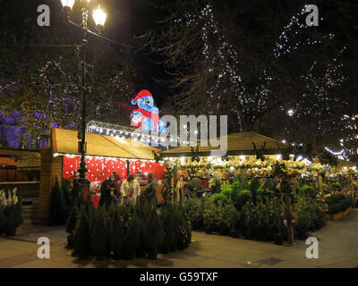 Scena notturna con le persone lo shopping al mercato in stallo con alberi di Natale sul mercato Albert Square a Manchester in Inghilterra Foto Stock