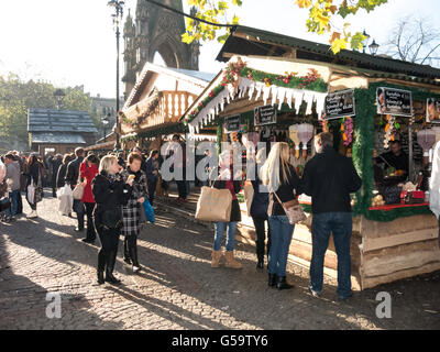 People shopping a bancarelle del mercatino di Natale in piazza Albert a Manchester in Inghilterra, Regno Unito Foto Stock