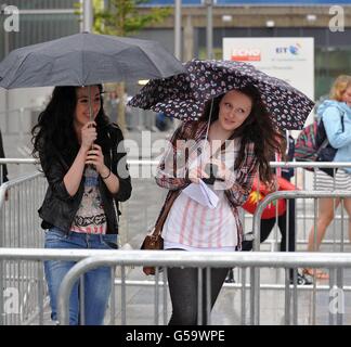 I fan che aspettano sotto la pioggia prima dell'X Factor Bootcamp all'Echo Arena di Liverpool. PREMERE ASSOCIAZIONE foto. Data immagine: Giovedì 19 luglio 2012. Il credito fotografico dovrebbe essere: David Richards/PA Wire Foto Stock