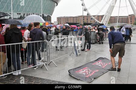 I fan che aspettano sotto la pioggia prima dell'X Factor Bootcamp all'Echo Arena di Liverpool. PREMERE ASSOCIAZIONE foto. Data immagine: Giovedì 19 luglio 2012. Il credito fotografico dovrebbe essere: David Richards/PA Wire Foto Stock