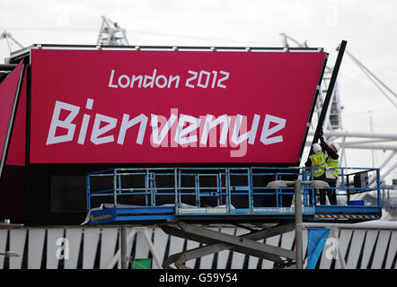 Olympics - preparativi per la finale del Parco Olimpico. Gli operai applicano gli ultimi tocchi ad un cartello di benvenuto nel parco olimpico di Stratford, Londra. Foto Stock