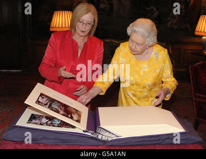 Tricia Marwick MSP, presidente del Parlamento scozzese, mostra alla regina Elisabetta II un libro di fotografie delle visite della regina al Parlamento scozzese, dato a sua Maestà come regalo giubilare durante un'udienza privata al Palazzo di Holyroodhouse a Edimburgo. Foto Stock