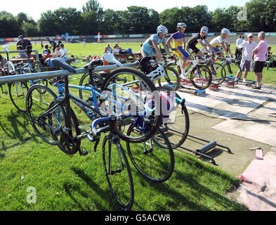 I ciclisti si riscaldano prima di una gara al velodromo Herne Hill, a sud-est di Londra, mentre decine di giubilanti appassionati di ciclismo celebravano lo storico Tour de France di Bradley Wiggins vincono oggi in pista dove per la prima volta ha sperimentato l'emozione delle corse. Foto Stock