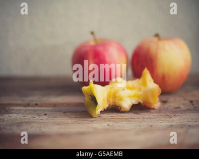 Un nucleo di Apple con due mele intere sullo sfondo. Vintage stile pellicola applicata. Foto Stock