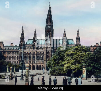 Das gotische Rathaus ist wohl der wirkungsvollste Profanbau der ganzen Stadt. Es wurde 1872 - 1882 erbaut und bedeckt mit den Höfen einen Raum von 19.430 qm. Die Höhe der Dachfirste ist 36 m, die des Turmes 107 m. Oben an der Fassade sind Standbilder der bedeutendsten Männer der Stadt aufgestellt. Da die Stadt Wien - wie erwähnt - ein eigenes Land bildet, das 248 qkm umfaßt und 1.865.000 Einwohner hat, ist die Stadtverwaltung zugleich auch die Regierung des Landes. Außerdem haben hier die Behörden der Republik Österreich und wie schon hervorgehoben wurde, die des Landes Niederösterreich ihren Foto Stock