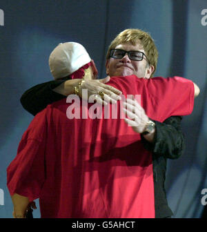 Sir Elton John abbracca il cantante rap americano Eminem prima di presentarlo con il miglior artista internazionale durante i Brit Awards 2001, presso Earls Court a Londra. Foto Stock