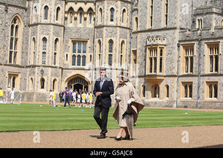La regina Elisabetta II e il presidente del LOCOG Lord Sebastian Coe cammina fuori dal Castello di Windsor, Berkshire, che era sulla rotta del relè olimpico della torcia. Foto Stock