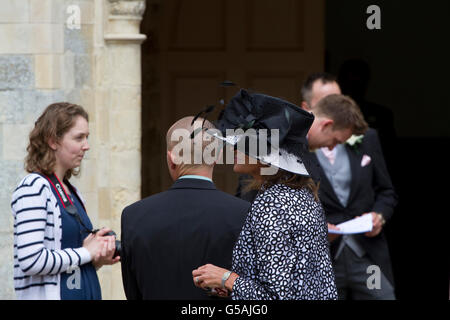 Spettacolare matrimonio hat al di fuori di una chiesa come il partito attende la sposa. Foto Stock