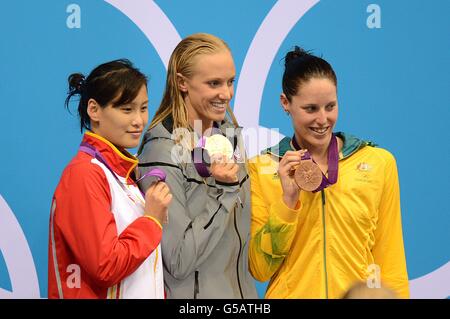 La vincitrice della medaglia d'oro degli Stati Uniti Dana Vollmer (al centro), la vincitrice della medaglia d'argento cinese Ying Lu (a sinistra) e la vincitrice della medaglia di bronzo australiana Alicia Coutts (a destra) festeggiano dopo la finale delle farfalle da 100 m femminili Foto Stock