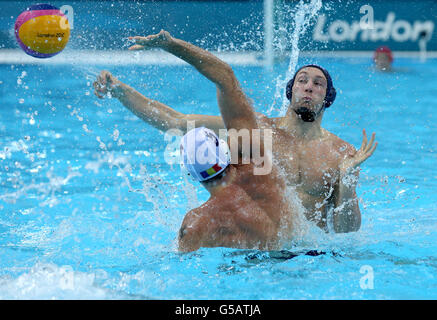 La Gran Bretagna Rob Parker (a destra) combatte per la palla contro la Romania nel Mens Water Polo preliminare gruppo B partita alla Water Polo Arena nel Parco Olimpico di Londra. Foto Stock