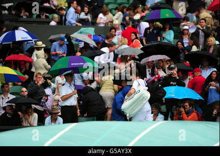 Andy Murray della Gran Bretagna si allontana mentre la pioggia inizia a cadere su Center Court nella sua partita contro Roger Federer della Svizzera nella finale maschile di Singles durante il tredici° giorno dei Campionati Wimbledon del 2012 presso l'All England Lawn Tennis Club di Wimbledon. Foto Stock