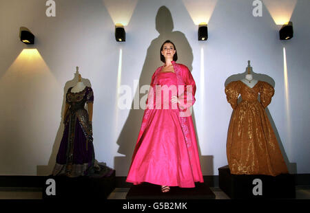 Modella Eve Armstrong, indossando l'abito in taffeta di seta rosa indossato da Madonna nel film evita, in una mostra di costumi di Hollywood come parte della mostra di Stitches creativi e Hobbycrafts presso lo Scottish Exhibition and Conference Centre di Glasgow. *... Sono anche raffigurati un damask arancione e di seta indossato da Liv Tyler nel film Onegin, e un costume in due pezzi di seta viola incrostata di gioiello indossato da Elizabeth Taylor che gioca Aida nel film Young Toscanini. Foto Stock