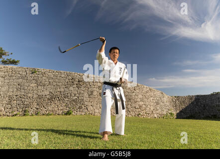 Katsuyoshi Chibana 7 dan Okinawa SHORIN-RYU Karate-do Myobu-kan formazione con battenti kama a Castello Zakimi, Okinawa Foto Stock