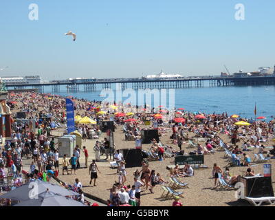 La gente sulla spiaggia di Brighton oggi che è stato il giorno più caldo dell'anno finora dopo che il mercurio è aumentato vicino a 30C (86F). Foto Stock