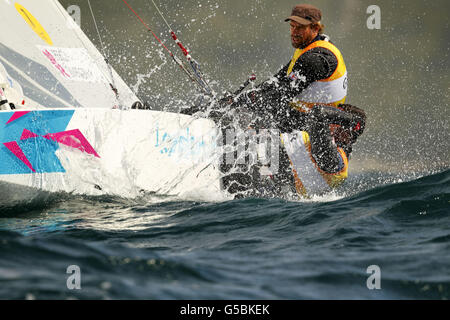 La Gran Bretagna Iain Percy e Andrew Simpson si schiantano attraverso il pesante rigonzamento mentre competono nella classe Star sulla baia di Weymouth. Foto Stock