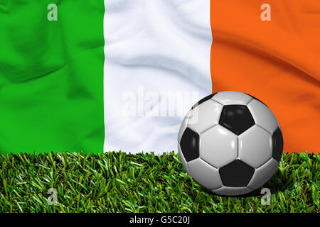 3D reso pallone da calcio in erba campo con l'Irlanda bandiera come sfondo Foto Stock
