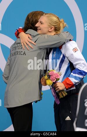 La Katie Ledecky degli Stati Uniti abbraccia la Rebecca Adlington della Gran Bretagna (a destra) dopo la cerimonia di presentazione per il Freestyle delle Donne da 800 m presso l'Aquatics Center nel Parco Olimpico di Londra, il settimo giorno delle Olimpiadi di Londra del 2012. Foto Stock