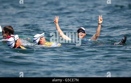 Il grande britannico Luca Patience (a destra) celebra la vittoria della medaglia d'argento nella classe 470 maschile saltando nelle acque al largo di Weymouth con il suo compagno di squadra Stuart Bithell durante il quattordici° giorno delle Olimpiadi di Londra del 2012. Foto Stock