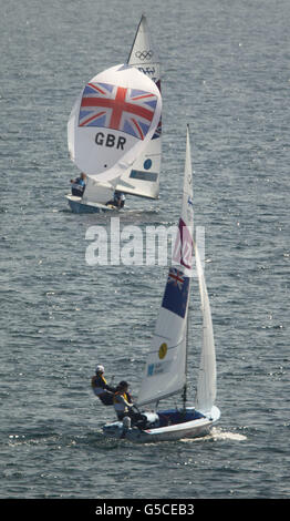 Hannah Mills, medaglia d'argento della Gran Bretagna, e Saskia Clark (TOP), hanno seguito la squadra neozelandese vincitrice della medaglia d'oro di Jo Aleh e Olivia Powrie durante il Medal Racel nella classe femminile 470 presso la sede delle Olimpiadi di Weymouth e Portland. Foto Stock