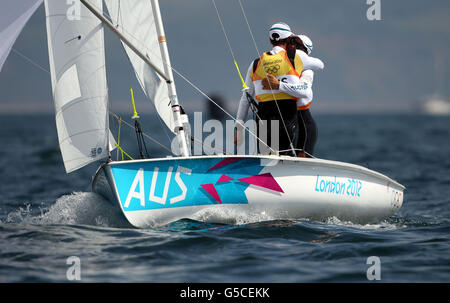 I vincitori australiani della medaglia d'oro 470 Mathew Belcher e Malcolm Page festeggia mentre attraversano la linea vincente durante la medaglia di oggi Gara alla regata olimpica di Weymouth oggi Foto Stock