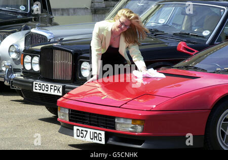 L'impiegato di Christie Cynthia Paris elargisce il cofano della rock star Elton John's 1987 Ferrari Testarossa, in vista di un'asta di 20 auto dalla sua collezione a Christie's, a Londra, il 05/06/01. Foto Stock