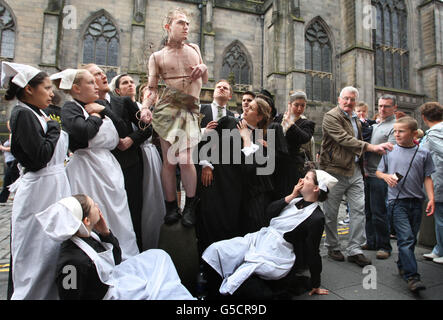 Edinburgh Fringe Festival ACT Edipus l'ora si esibiscono sul Royal Mile per pubblicizzare il loro spettacolo nella prima settimana del festival. Foto Stock