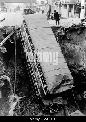 Un autobus si trova in un cratere a Balham, a sud di Londra, a seguito di un'esplosione di bombe notturna durante il blitz. Foto Stock