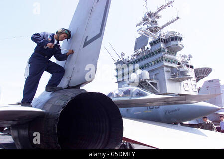 Un tecnico di aeromobili lavora su un F14 Tomcat a bordo della portaerei della marina statunitense, USS Enterprise ormeggiata nel Solent. La nave è ancorata al largo di Portsmouth, nel Hamshire per una visita di tre giorni in Inghilterra prima di prendere parte agli esercizi. Foto Stock