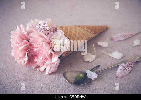 Rosa fiori di garofano nel gelato cono di cialda Foto Stock