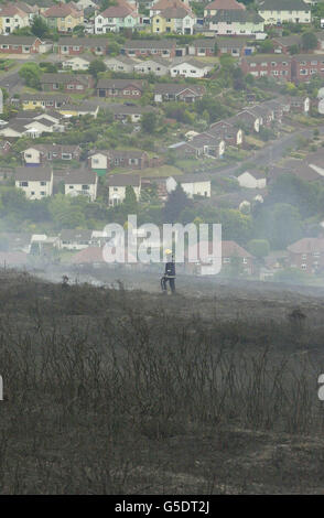 Un membro di un equipaggio di vigili del fuoco che controlla un blaze delle brughiere che ha distrutto circa 30 acri sparsi attraverso la gola e le brughiere sul luogo di bellezza di North Hill che si affaccia su Minehead, Somerset. I villeggianti di un campeggio vicino al blaze sono stati evacuati come precauzione. *il blaze scoppiò su quattro acri di gorse, con gli equipaggi antincendio e le unità specializzate del Somerset e del vicino Devon che lavoravano per controllarlo durante la notte. Foto Stock