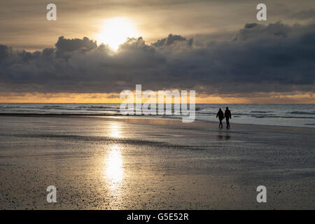 Walkers a costa, luce della sera, al tramonto con nuvole, Norderney, Est Frisone Isola, Frisia orientale, Bassa Sassonia, Germania Foto Stock