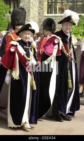 La regina Elisabetta II si erge con il duca di Edimburgo che indossa il loro ordine delle vesti del Garter, mentre si portano alla Cappella di San Giorgio a Windsor, per la cerimonia annuale del Garter. Foto Stock