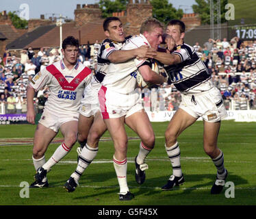 Anthony Stewart di St Helens (centro) è affrontato da Logan Campbell di Hull FC (seconda a sinistra) e Richard Horne (destra), durante la partita di Tetley's Bitter Super League al Boulevard Ground di Hull. Foto Stock