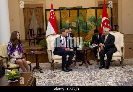 Il Duca di Cambridge chiacchiera con il presidente di Singapore Tony Tan mentre la Duchessa di Cambridge guarda (a sinistra) durante una visita all'Istana di Singapore, il giorno uno di un tour di nove giorni dell'Estremo Oriente e del Sud Pacifico in onore del Giubileo dei Diamanti della Regina. Foto Stock