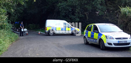 Polizia sulla scena in una corsia ad Ashill fuori dalla A358 vicino Ilminster, Somerset, dopo che una giovane donna è stata scoperta morta in una macchina in fiamme. Foto Stock