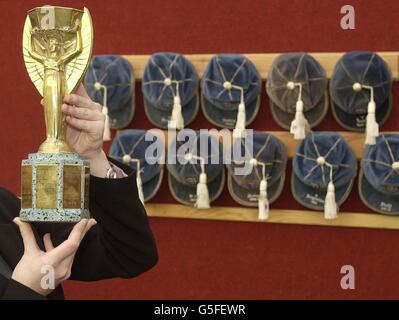 Rachel Dewhurst di Christie's detiene un trofeo Jules Rimet in replica di metallo giallo davanti ai caps inglesi vinti da Sir Alf Ramsey, manager della squadra vincitrice della Coppa del mondo d'Inghilterra 1966, nell'ufficio centrale di Londra della casa d'aste. I cimeli calcistici di Ramsey sono stati esposti oggi al Christie's, che comprende cappelli internazionali, medaglie di campionato vinte come giocatore e manager e oggetti delle finali della Coppa del mondo 1966. La collezione è prevista per il 50,000 e andrà sotto il martello durante la vendita annuale di cimeli calcistici il 27 settembre. Foto Stock