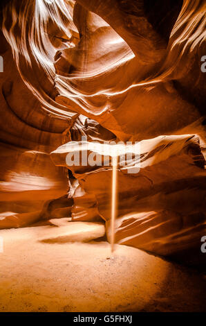 Sole che colpisce la sabbia che cade da una scogliera in Antelope Canyon, Arizona. Incredibile slot canyon, territorio Navajo. Colore. Foto Stock