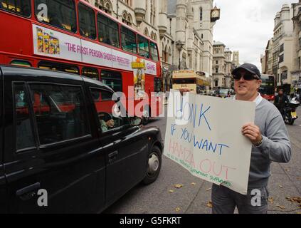 Un manifestante detiene un cartello a sostegno della proposta estradizione del predicatore radicale Abu Hamza e di altri quattro sospetti di terrore al di fuori della Corte di giustizia reale, nel centro di Londra. Foto Stock