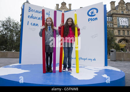 Le studentesse di 10 anni Elisha Kendall di Bolton (a sinistra) e Anastasia Barlow, di Bury (a destra), firmano l'installazione del libro di Plan UK nella piazza di scambio di Manchester per evidenziare l'importanza dell'istruzione per le ragazze di tutto il mondo nella corsa fino alla Giornata Internazionale della ragazza l'11 ottobre. Foto Stock